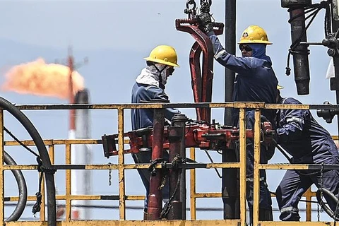 Công nhân làm việc tại nhà máy lọc dầu ở Acacias, phía Nam Bogota (Colombia). (Ảnh: AFP/TTXVN)