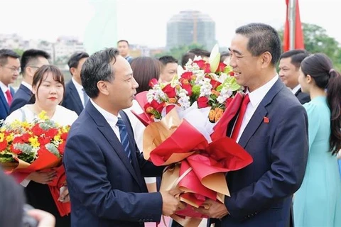 Lãnh đạo thành phố Móng Cái tặng hoa đón Đoàn tại Cửa khẩu Quốc tế Móng Cái. (Ảnh: TTXVN phát)