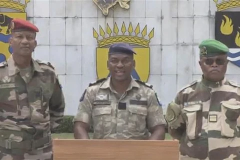 Phát ngôn viên Ủy ban Chuyển tiếp và Khôi phục Thể chế (CTRI) Gabon - được lập ra sau cuộc binh biến của nhóm sỹ quan cấp cao quân đội nước này - Đại tá Ulrich Manfoumbi Manfoumbi (giữa) phát biểu trên truyền hình ngày 2/9/2023. (Ảnh: AFP/TTXVN)