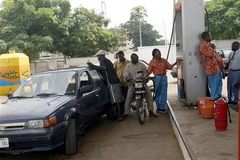 Bơm xăng cho các phương tiện tại trạm xăng ở Lagos (Nigeria). (Ảnh: AFP/TTXVN)