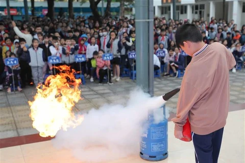 Hướng dẫn học sinh Trường Tiểu học Ngọc Khánh, quận Ba Đình (Hà Nội) sử dụng bình chữa cháy và thực hành dập tắt đám cháy. (Ảnh: Thanh Tùng/TTXVN)