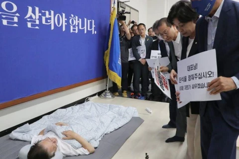 Các nhà lập pháp kêu gọi ông Lee Jae-myung (nằm trên sàn) chấm dứt tuyệt thực. (Ảnh: Yonhap/The Korea Herald)
