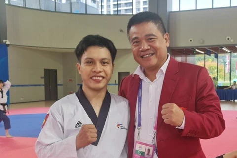 Võ sỹ Trần Hồ Duy (trái) chính thức có Huy chương Đồng nội dung Quyền Cá nhân Nam môn Taekwondo. (Nguồn: Thanh Niên)
