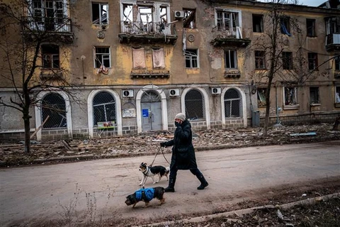 Một người dân di chuyển qua tòa nhà bị hư hại trong xung đột Nga-Ukraine tại Chasiv Yar, miền Đông Ukraine ngày 5/1/2023. (Ảnh: AFP/TTXVN)