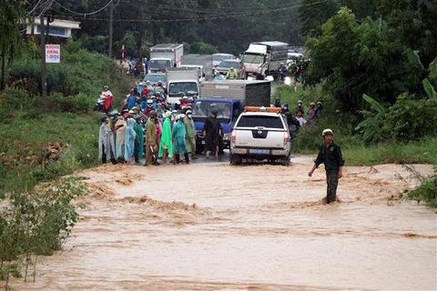 Mưa lớn làm Tỉnh lộ 675 đi từ huyện Sa Thầy về thành phố Kon Tum bị ngập khiến người và phương tiện không thể lưu thông. (Ảnh: Cao Nguyên/TTXVN)