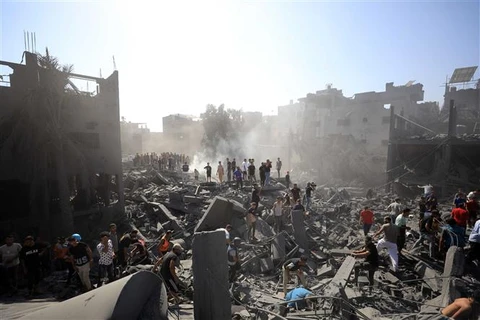Người dân tìm kiếm người sống sót dưới đống đổ nát tại Dải Gaza sau các cuộc không kích của Israel ngày 26/10/2023. (Ảnh: THX/TTXVN)