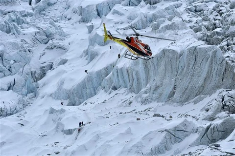 Trực thăng bay trên núi thuộc khu vực Everest (Nepal). (Ảnh: AFP/TTXVN)