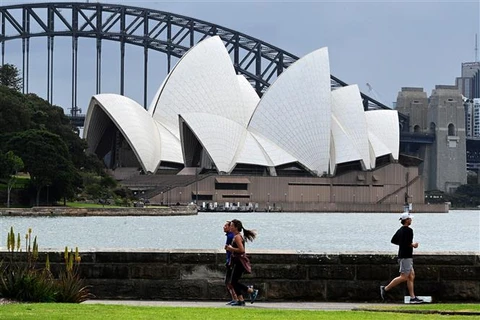 Người dân tập thể dục tại khu vực Cầu cảng Sydney, bang New South Wales (Australia). (Ảnh: AFP/TTXVN)