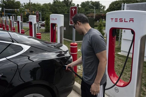 Người dân sạc điện cho ôtô tại một trạm sạc của Tesla ở Arlington, Virginia (Mỹ). (Ảnh: AFP/TTXVN)