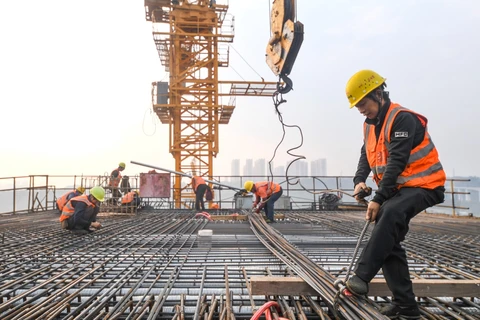 Công nhân làm việc tại công trình xây dựng ở Trùng Khánh (Trung Quốc). (Ảnh: THX/TTXVN)