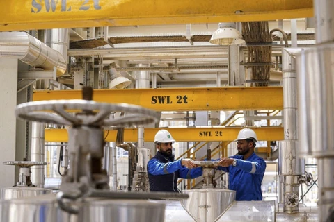 Công nhân làm việc tại một nhà máy lọc dầu ở Karbala (Iraq). (Ảnh: AFP/TTXVN)