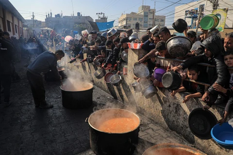 Người dân chờ nhận thực phẩm cứu trợ tại thành phố Rafah, phía Nam Dải Gaza ngày 31/12/2023. (Ảnh: THX/TTXVN)