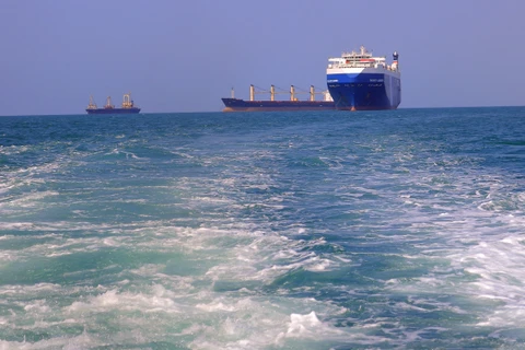 Một tàu chở hàng (phải), bị lực lượng Houthi bắt giữ, trên đường về cảng tỉnh Hodeida (Yemen), ngoài khơi Biển Đỏ, ngày 22/11/2023. (Ảnh: AFP/TTXVN)