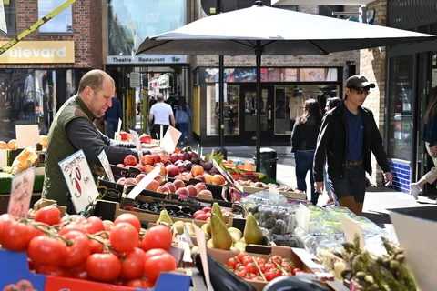 Người dân mua sắm tại một chợ ở London (Anh). (Ảnh: AFP/TTXVN)