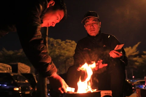 Người dân đốt lửa sưởi ấm gần cầu Long Biên (Hà Nội), tháng 12/2023. (Ảnh: Hoàng Hiếu/TTXVN)
