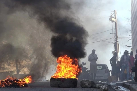 Lốp xe bốc cháy gần Nhà tù Quốc gia ở Port-au-Prince, Haiti, sau khi hàng nghìn tù nhân vượt ngục ngày 3/3/2024. (Ảnh: AFP/TTXVN)