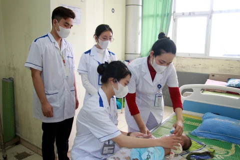 Nguyễn Thị Thanh Thảo (ngồi) thực tập tại Bệnh viện Nhi Nam Định. (Ảnh: Nguyễn Lành/TTXVN)