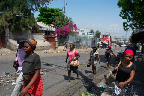 Người dân chạy trốn khỏi khu vực xảy ra đụng độ ở Port-au-Prince (Haiti), ngày 20/3/2024. (Ảnh: AFP/TTXVN)