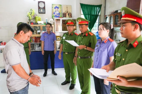 Cơ quan Điều tra tống đạt quyết định khởi tố bị can, lệnh bắt tạm giam đối với Nguyễn Văn Tuấn. (Ảnh: TTXVN phát)