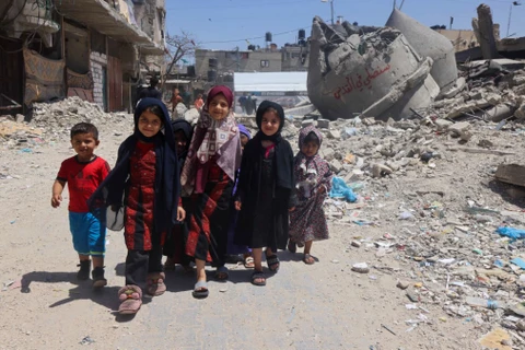 Trẻ em Palestine tại khu vực đổ nát sau các cuộc oanh tạc của Israel xuống thành phố Rafah, phía Nam Dải Gaza, ngày 19/4/2024. (Ảnh: AFP/TTXVN)