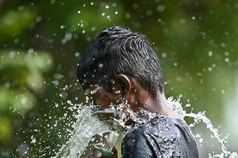 Trẻ em chơi đùa với nước để giải nhiệt trong ngày nắng nóng tại Chennai (Ấn Độ), ngày 28/5/2024. (Ảnh: AFP/TTXVN)