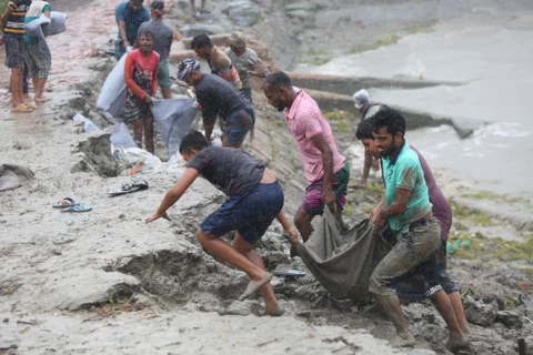 Cư dân địa phương tu sửa bờ kè bị bão Remal phá hủy ở Khulna (Bangladesh), ngày 27/5/2024. (Ảnh: THX/TTXVN)