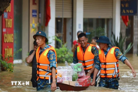 Lực lượng Quân đội, Công an, dân quân giúp dân xã Bát Tràng, huyện Gia Lâm (Hà Nội) di chuyển ra khỏi vùng ngập lụt. (Ảnh: Thanh Tùng/TTXVN)