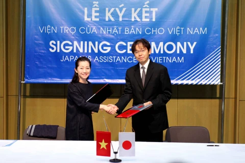 Bà Naomi Amaike (giám đốc tổ chức JOICFP) và ngài Phó Đại sứ Nhật Bản Yanagi Jun hoàn thành việc ký kết hợp đồng cung cấp viện trợ. (Ảnh: Doãn Đức/Vietnam+)