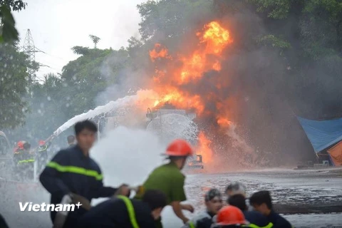 Nỗ lực dập lửa tại cây xăng chợ đầu mối Đền Lừ. (Ảnh: Minh Sơn/Vietnam+)