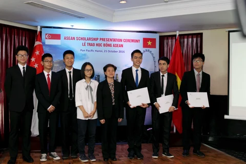 Đại sứ Singapore Catherine Wong (áo đen, ở giữa) chụp ảnh lưu niệm cùng các em học sinh nhận học bổng. (Ảnh: PV/Vietnam+)