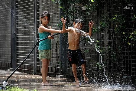 Trẻ em nghịch nước để làm dịu cơn nóng (Nguồn:Télam)