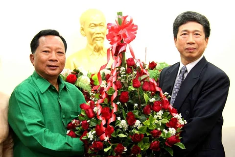 Trung tướng Chansamone Channhalath (trái) tặng hoa chúc mừng Tết Giáp Ngọ Việt Nam. (Ảnh: Hoàng Chương/Vietnam+)