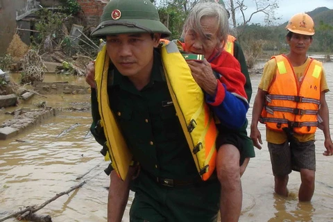 Bộ đội Biên phòng tỉnh Quảng Bình sơ tán người già ở Quảng Trạch ra khỏi vùng lũ ngày 16/10/2013. (Ảnh: Đức Thọ/TTXVN)