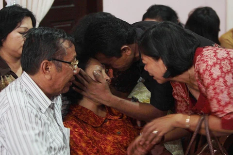 Cha mẹ của một hành khách người Indonesia đau khổ sau khi nghe tin máy bay mất tích. (Nguồn: AFP/TTXVN)
