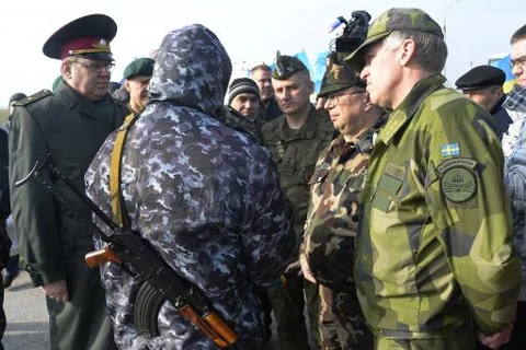 Quan sát viên OSCE đàm phán với tự vệ Crimea tại một chốt gác dẫn vào Crimea hôm 7/3 (Nguồn: AFP)