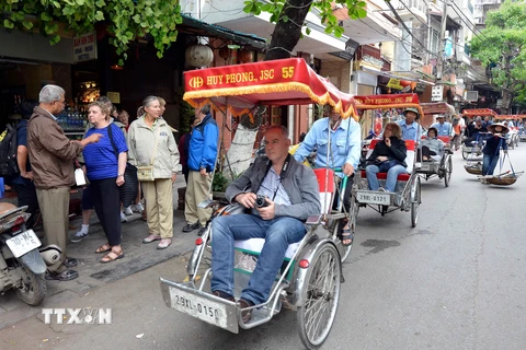 Du khách nước ngoài tham quan Hà Nội bằng xích lô. (Ảnh: Thanh Hà/TTXVN)