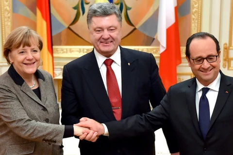 Thủ tướng Đức Angela Merkel và Tổng thống Pháp Francois Hollande bắt tay với Tổng thống Ukarine Petro Poroshenko ở Kiev, tháng 2/2015. (Nguồn: Ukrainian Presidential Press Service)