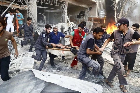 Vận chuyển người bị thương trong một cuộc giao tranh giữa quân chính phủ và phe nổi dậy ở Douma, phía Đông thủ đô Damascus của Syria.. (Nguồn: AFP)