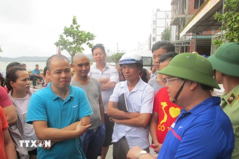 Bí Thư Huyện ủy Cô Tô Hoàng Bá Nam thăm hỏi động viên khách du lịch đang mắc kẹt lại trên đảo. (Ảnh: Thu Báu/TTXVN phát)