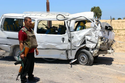Một thành viên lực lượng an ninh Ai Cập đứng gác bên cạnh chiếc xe chở cảnh sát bị tấn công hôm 9/9 ở phía bắc Sinai. (Nguồn: AFP) 
