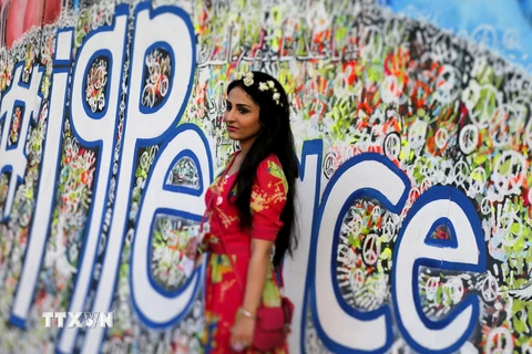 Một phụ nữ Iraq tham gia lễ kỷ niệm chụp ảnh bên cạnh một bức tranh cổ động cho Ngày quốc tế Hòa bình. (Nguồn: Reuters)