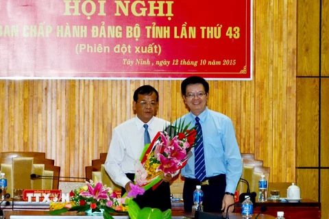 Ông Mai Văn Chính, Ủy viên Trung ương Đảng, Phó trưởng Ban Tổ chức Trung ương (phải) tặng hoa chúc mừng ông Phạm Văn Tân. (Ảnh: Thanh Tân/TTXVN)