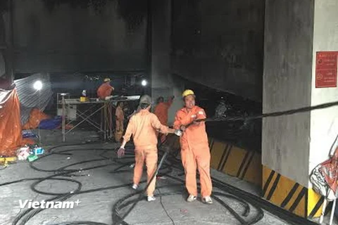 Công nhân kéo cáp điện vào tòa nhà CT4B và CT4C. (Ảnh: Mạnh Khánh/Vietnam+)