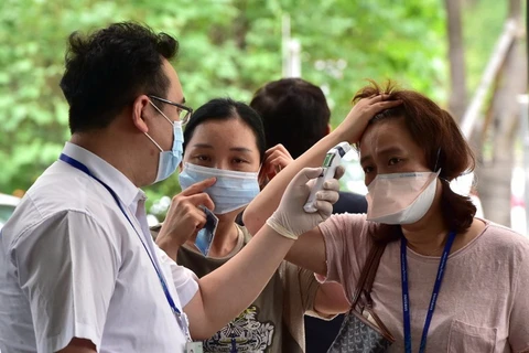 Đo thân nhiệt cho khách vào trung tâm y tế Samsung ở phía Nam Seoul, ngày 20/7. (Nguồn: AFP)