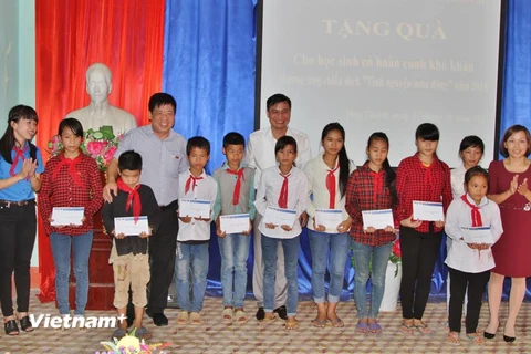 Đại diện đoàn công tác trao quà cho các em học sinh khó khăn vượt khó ở trường trung học cơ sở Hợp Thành. (Ảnh: Lê Sơn/Vietnam+)