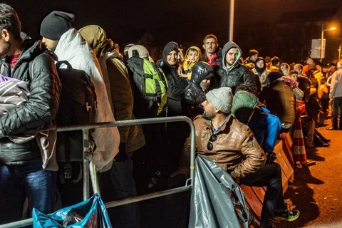 Dòng người tị nạn đứng đợi ở khu vực cầu Simbach am Inn, biên giới Áo-Đức, ngày 25/10. (Nguồn: AFP)