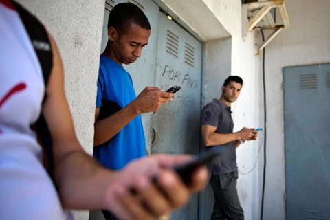 Sinh viên Cuba sử dụng điện thoại di động để truy cập Internet. (Nguồn: AP)