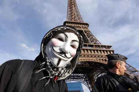 Một người biểu tình đeo mặt nạ Anonymous Guy Fawkes, biểu tượng của Anonymous trong một cuộc tuần hành dưới chân tháp Eiffel, Paris. (Nguồn: AFP) 