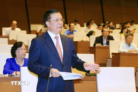 Bộ trưởng Bộ Tài chính Đinh Tiến Dũng trả lời câu hỏi chất vấn của đại biểu Quốc hội. (Ảnh: Doãn Tấn/TTXVN)