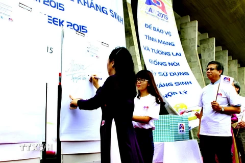 Bộ trưởng Bộ Y tế Nguyễn Thị Kim Tiến ký cam kết phòng chống kháng thuốc. (Ảnh: Dương Ngọc/TTXVN)